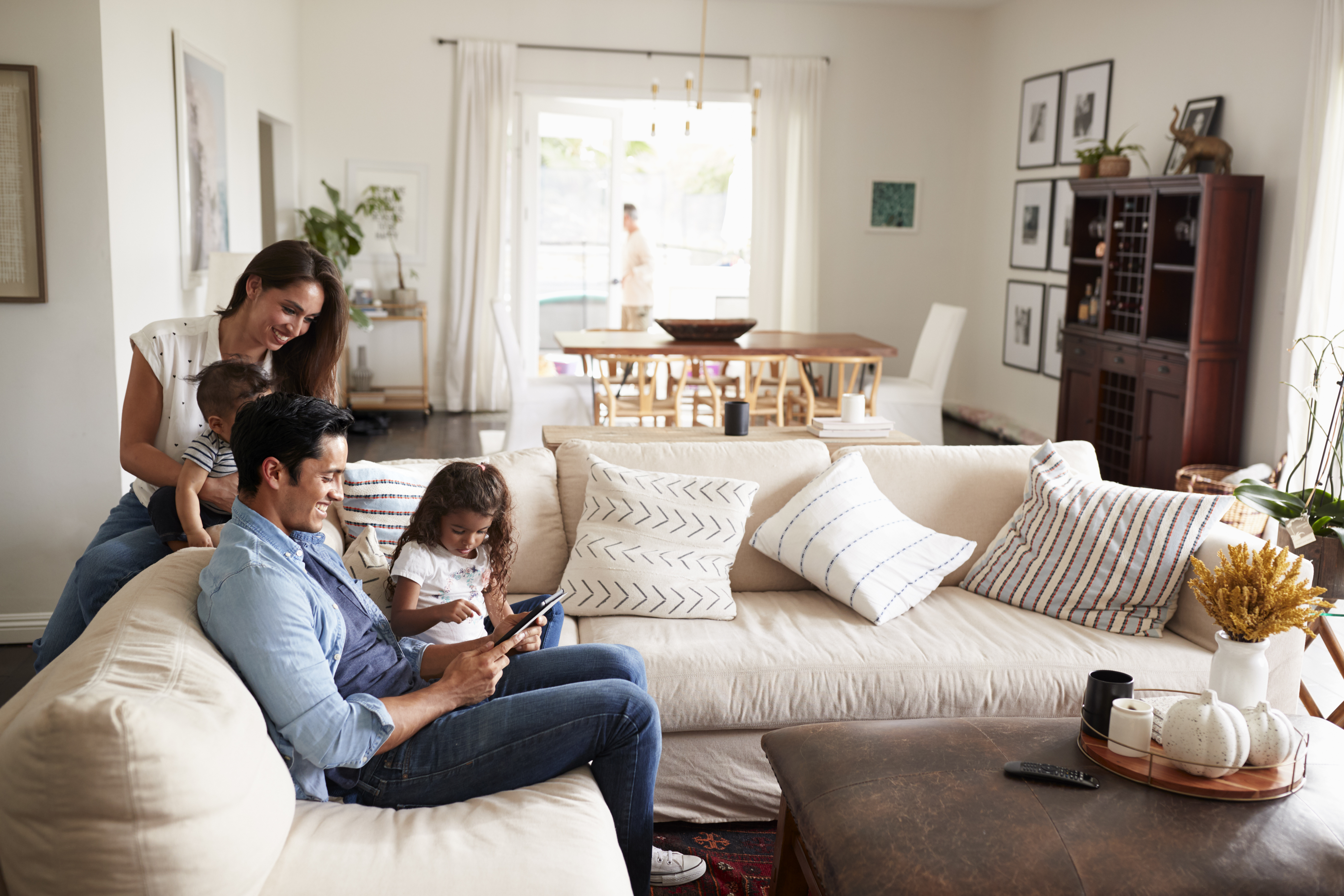 young hispanic family sitting on sofa reading a bo 64c172027b3c59a519e5