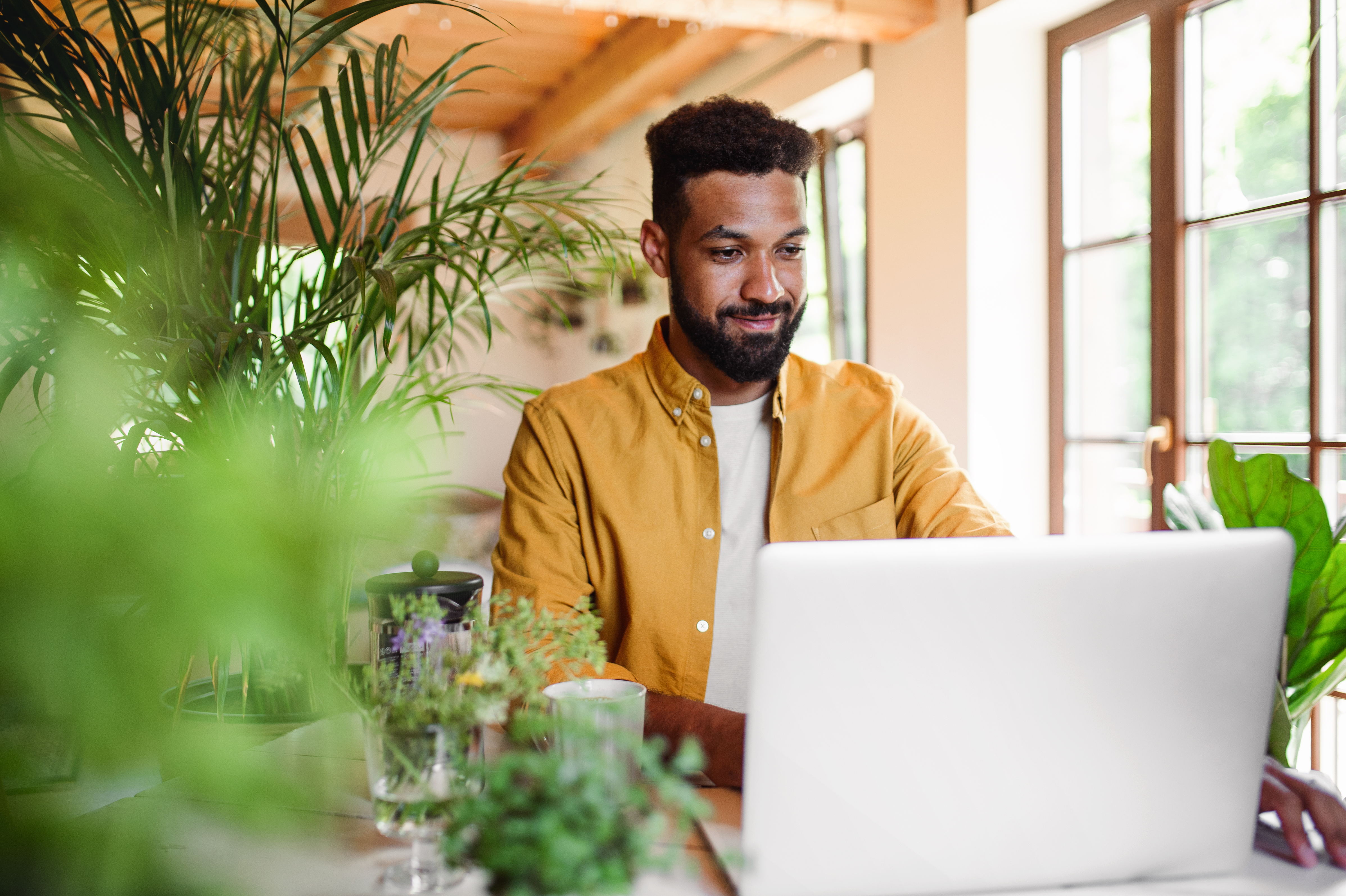 young man with laptop and coffee working indoors 949e0f7ac85c5d4c1aaf