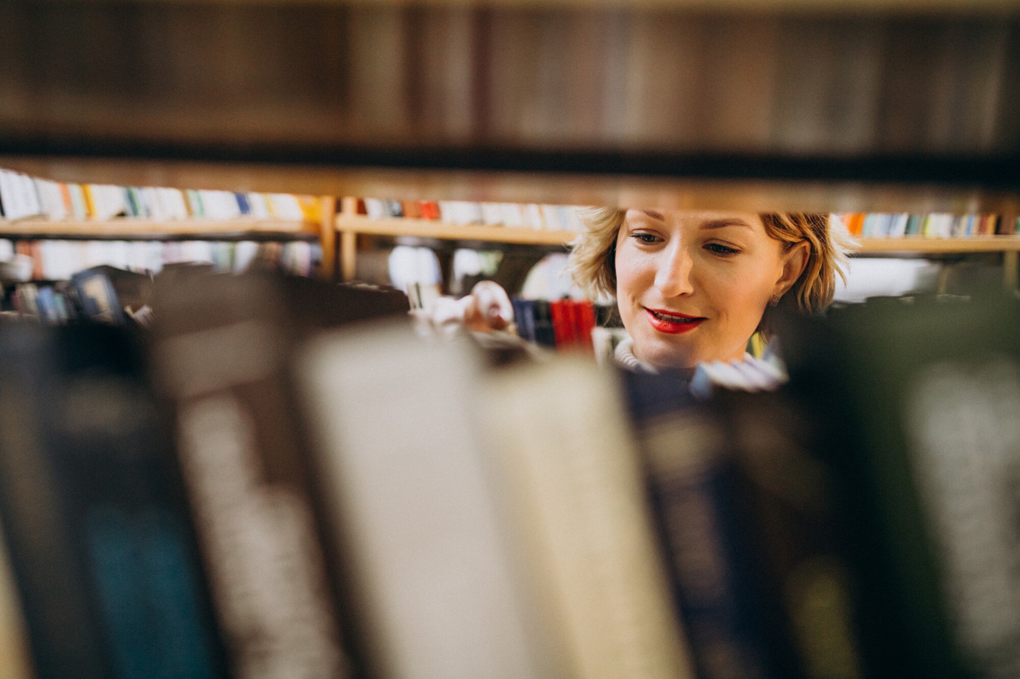 young woman choosing book at the library c73486067a561c54d68e