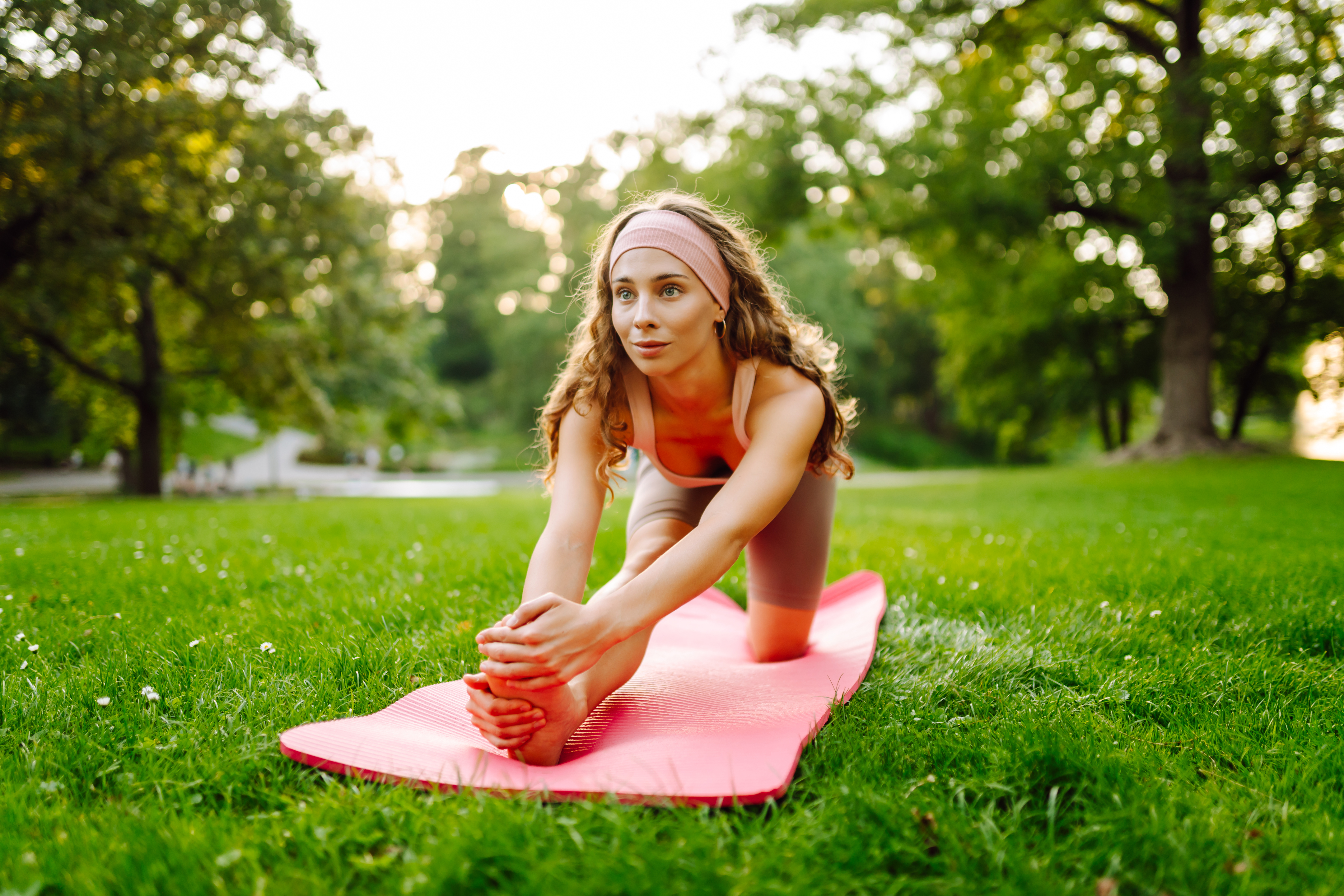 young woman meditating on mat in sunny park bd60982be6d4cd0428b0